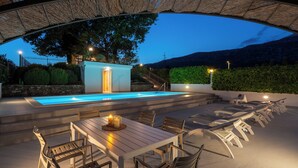 An outdoor pool area with a table and chairs, a small building, and a staircase leading up to a hill. - Villa PROVOS with 40m2 private pool, sauna, max 8 person, 7km from sandy beach (TUGARE)