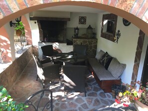 An outdoor patio area with stone flooring, wicker furniture, and a stone fireplace. - Villa With Private Pool And Jacuzzi (Bay of Kotor)