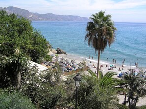 Ein Strand mit Sonnenschirmen und Personen.
