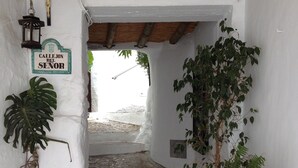 Un étroit sentier de pierres mène à une porte sur laquelle est apposée une plaque indiquant « Callejon del Senor ».