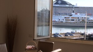 Un comedor con vista a un crucero amarrado en un puerto deportivo.