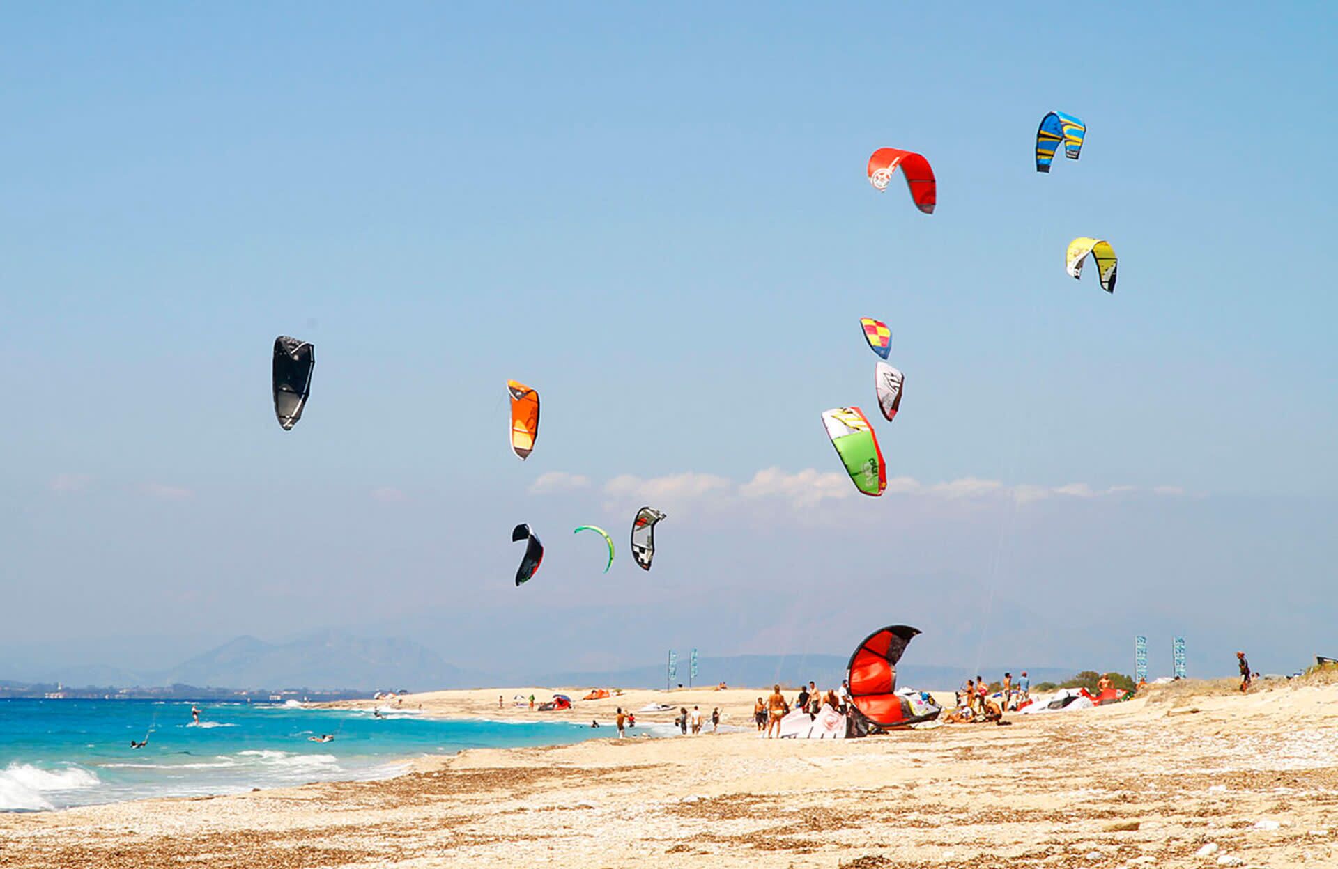 A beach with people and kites.