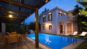 A two-story house with a swimming pool, wooden deck, and outdoor seating area. - Aeriko-Varko Beachfront Villa with Stunning View and Private Pool (LEFKADA)