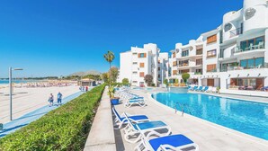A resort with a pool, sun loungers, and a beach area. - Blue Lagoon Apartment, 10 m from the beach, 2 Swimmingpools, for 4 People (Alcúdia)