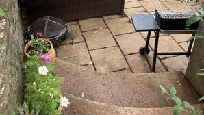 A patio area with wicker furniture, a grill, and potted plants. - Barn Conversion, 5 miles from the coast with own parking and garden (Collaton St Mary)