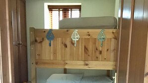A bunk bed with a wooden headboard, a window with blinds, and a door on the side. - Barn Conversion, 5 miles from the coast with own parking and garden (Collaton St Mary)