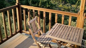 A wooden deck with a table and chair, overlooking a coastal landscape with trees and the sea. -  Pool Villa Perivoliou walking distance to 4 beaches, near Mamma Mia Church (Northern Sporades)