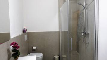 Een douche, een haardroger, een bidet, handdoeken