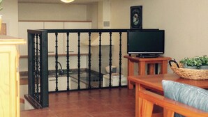 A living room with a wooden TV stand, a television, a sofa, and a small table. - OFFER season 2025. Spectacular ocean and cliff views (Puerto Santiago. Los Gigantes)