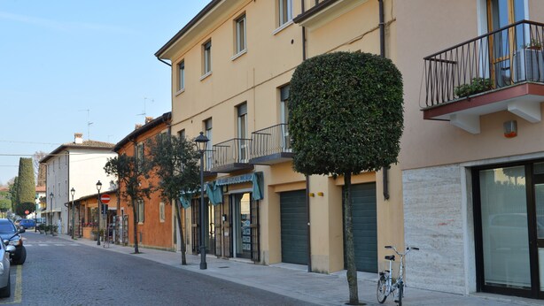 A street with buildings, a bicycle, and a no-entry sign.