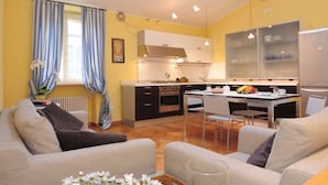 A compact living space with a kitchenette, a dining area, and a sofa.
