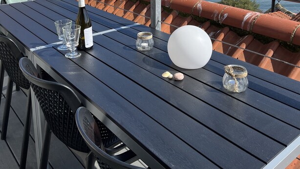 A terrace with a table set for two, overlooking a coastal view. - Runswick Bay Top Gallant Cottage - outside seating  - sea and beach views (Runswick Bay)