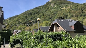 A residential area with houses, a street lamp, and a mountain in the background. - Chalet for 6 people in Cauterets with free parking space (Cauterets)