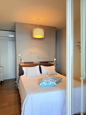 Une chambre à coucher avec un lit, des lampes de chevet, un luminaire fixé au mur et une citation inspirante.