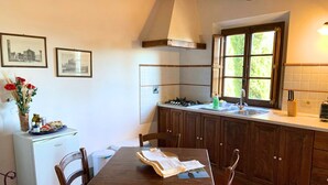 Una cocina compacta con una mesa de comedor, un refrigerador y una ventana que ofrece luz natural.