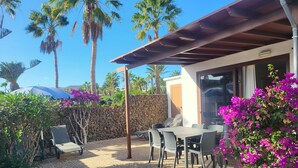 A patio area with a stone-tiled floor, outdoor furniture, and a pergola. - Villa 1A on the complex of Casas del Sol  (Playa Blanca)