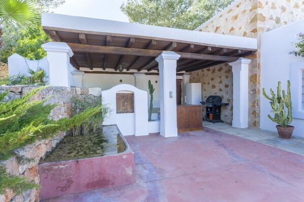 A covered outdoor area with a grill, a small pool, and a cactus plant. - Villa Savines close to Ibiza Town (Ibiza)