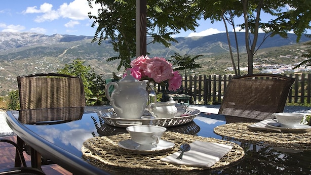 A table set for tea with a view of mountains.