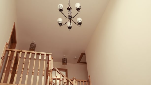 Eine Holztreppe mit einer Chandelüstere.