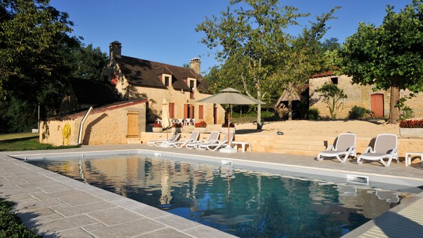 A swimming pool with lounge chairs and a covered seating area, surrounded by stone buildings and trees. - Very good location! Character house with private access to the river  (Vitrac)