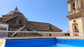 Una piscina con techo de azulejos y una torre de campanas.