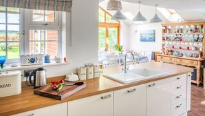 A kitchen with a large island, a built-in sink, and a window with a view of the outdoors.