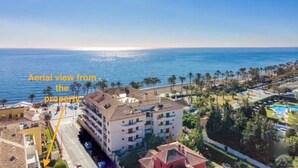 Vista aérea de una propiedad costera con acceso directo a la playa, edificios de varios pisos y una piscina.