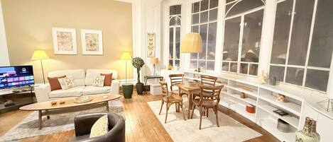 Un salon comprenant un canapé, une table basse et un coin repas avec des chaises et une table.
