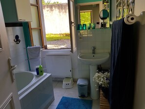 Een bad, een haardroger, handdoeken, toiletpapier