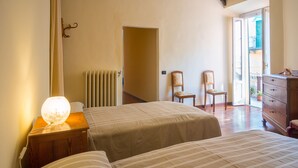 A bedroom with two beds, a nightstand with a lamp, a dresser, and a chair. - BELLAGIO'S SUNSET, appt with terrace and view of the lake in  Bellagio (Bellagio)