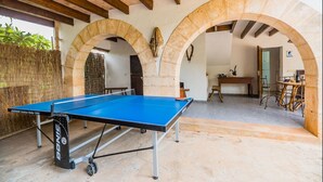 A ping pong table in an outdoor area with stone arches and a wooden ceiling. - Villa Can Boseta by SunVillas Mallorca (Pollença)