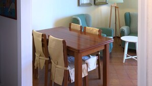 Un coin repas avec une table et des chaises en bois, un lampadaire et des tableaux encadrés accrochés au mur.