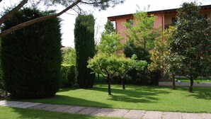 A well-maintained garden with a variety of trees and a paved pathway. - Modern apartment, Residence with swimming pool surrounded by greenery with FREE Wi-Fi (Sirmione)