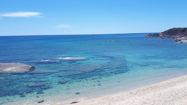 A beach with clear blue water and a rocky shoreline. - Villetta Brunetti Sant'Elmo (Castiadas)