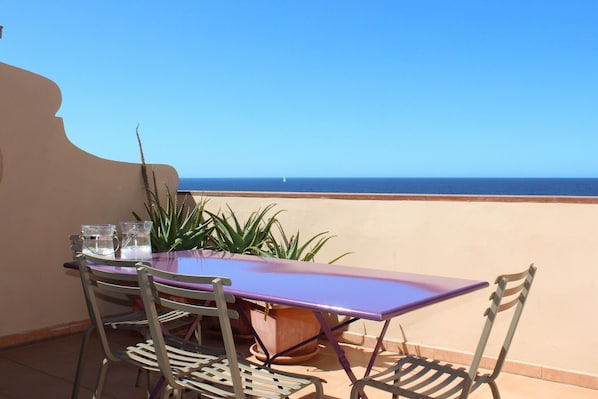 A table and chairs on a balcony with a view of the sea. - Apartment with terrace and view of the sea (Alghero)