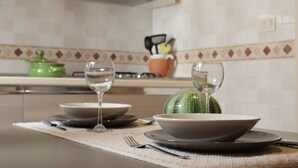 Een keuken met een eettafel, gedekt met borden, kommen en wijnglazen.