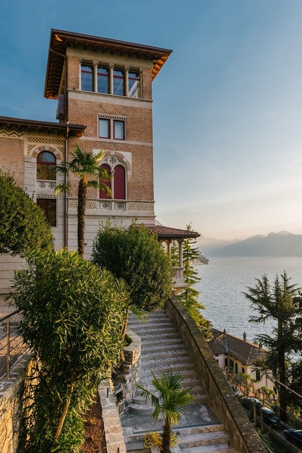 A two-story building with a balcony and a view of the sea.