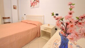 A bedroom with a bed, bedside table, and a vase with flowers. - Relax, wellness, italian elegance (Castellabate)