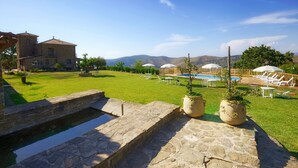 A pool area with lounge chairs and umbrellas, a stone staircase, and a stone building in the background. - Relax, wellness, italian elegance (Castellabate)