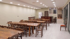 A dining area with multiple wooden tables and chairs, a refrigerator, and a staircase leading to an upper level. - Relax, wellness, italian elegance (Castellabate)