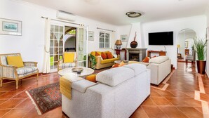 A spacious living room with a fireplace, a television, and a large window.