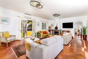 Un salón amplio con chimenea, televisor y un ventanal grande.