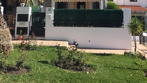 A two-story house with a tiled roof, a white exterior, and a small balcony with a striped awning. - 3 bedroom villa in Golf Resort, quiet, walking distance to beach, parking, pool (Torrequebrada Golf)