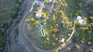 An aerial view of a property with a swimming pool, multiple buildings, and winding roads. - La Bolina-unique romantic holiday experience, private infinity pool, huge views (torrox)