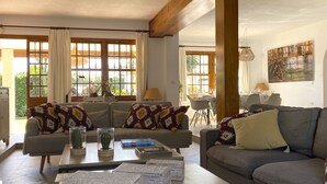A living room with a sofa, coffee table, and a dining area with chairs and a table. - Chalet in Puerto Marina, Benalmadena Costa. (Benalmádena)