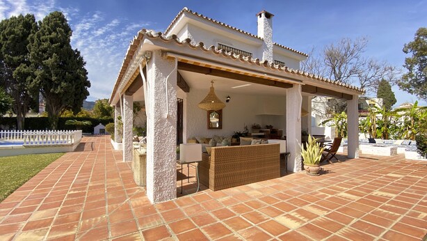 A covered patio area with outdoor seating, a hanging light fixture, and a view of the surrounding landscape. - Chalet in Puerto Marina, Benalmadena Costa. (Benalmádena)
