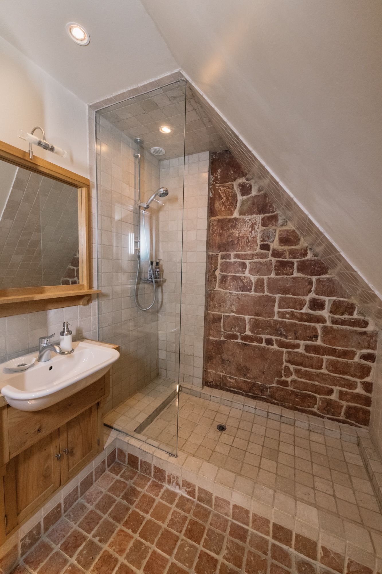 A bathroom with a shower, a sink, and a mirror.