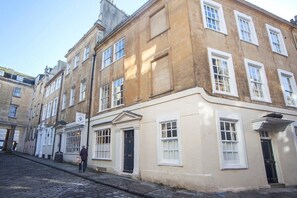 A historic building with multiple windows and a cobblestone street.