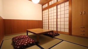A traditional Japanese room with tatami flooring, a low wooden table, and shoji screens.