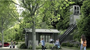 Een klein gebouw met een metalen dak, omgeven door bomen en een kabelbaan.